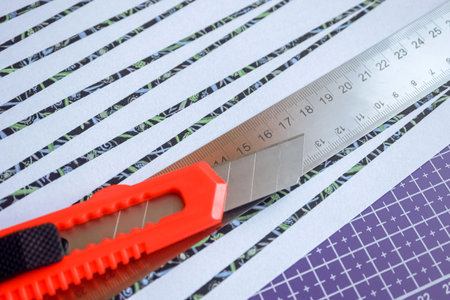Handmade paper bead templates of black colored floral patterns lying on a cutting mat with craft...