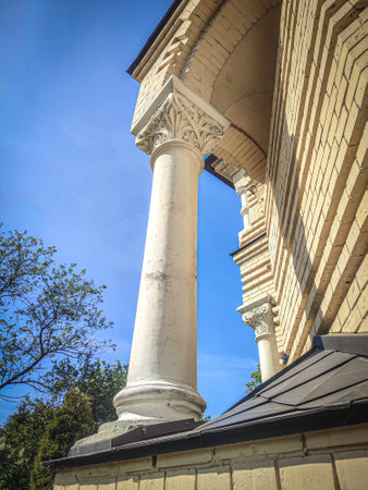 White building column of a orthodox church on Vilnius on blue sunny sky background bottom up viewの写真素材