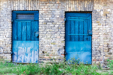 Two blue wooden doors in brick wall in the old town of Vilniusの写真素材