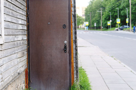 Old unusual door in wooden plant house corner on a cozy street in summerの写真素材