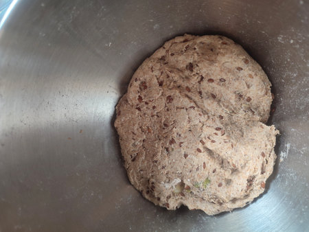 freshly mixed sourdough dough with starter ready for fermentation in a metal bowlの写真素材
