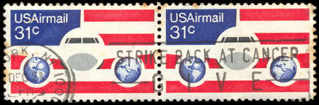 USA-CIRCA 1976: A 31 cent United States Airmail postage stamp, shows image of Plane and Globes on red white and blue background, circa 1976.のeditorial素材