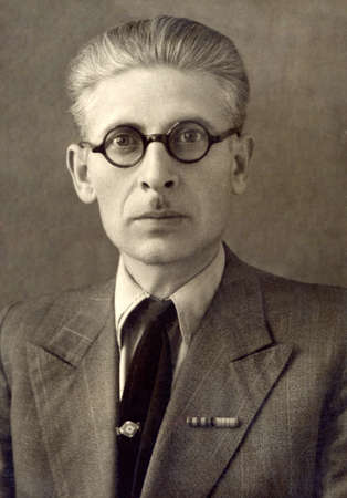 Russia, - CIRCA 1950s: An antique studio portrait of middle-aged man in a business suit, and glassesのeditorial素材