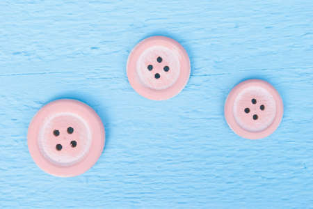 three pink buttons on blue wood backgroundの写真素材