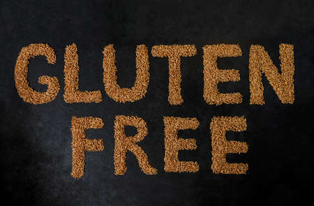 Gluten free. Spelt grains isolated on a black background, top view. Spelt seeds. Natural foods. Spelt. Gluten Gluten - free label. word made of spelt seeds. gluten free.の写真素材