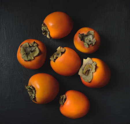 Persimmon on a dark background. Persimmon on a black background.の写真素材
