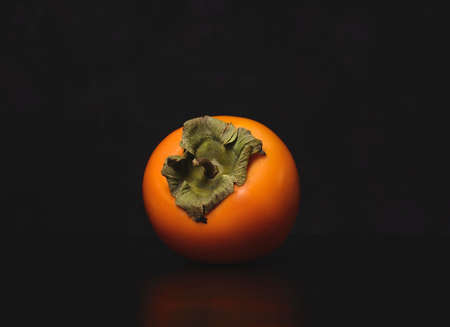 Persimmon on a dark background. Persimmon on a black background.の写真素材