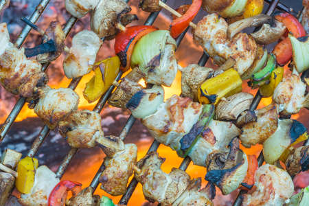 Grilled chicken shish kebab with colorful paprika, onion and button mushrooms on the grate. Barbeque (BBQ) timeの写真素材