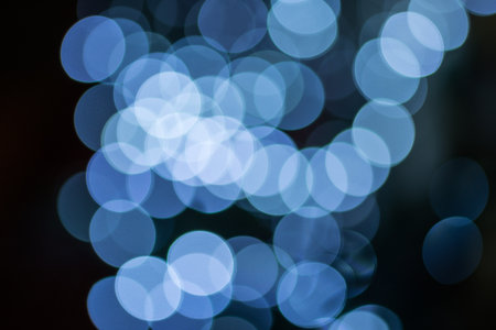 Christmas bokeh lights over dark background. Illumination and decoration concept.の写真素材