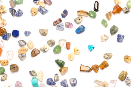 Different shapes of natural mini stone beads randomly spilled on white background.の写真素材