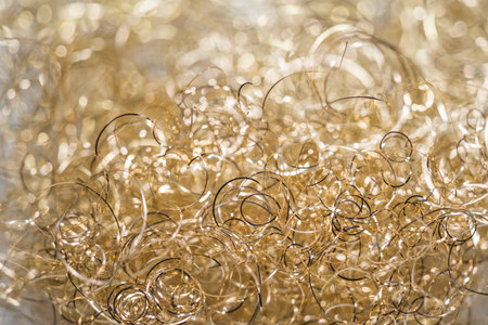 The light gold variant of metal angel hair. Christmas decorative material with bokehed background.