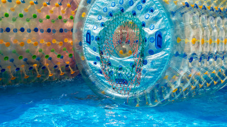 Walking water rollers for children playing in water reservoirs. Inflatable toy attractions in the water parkの写真素材