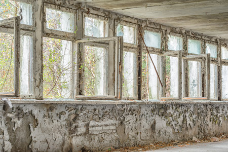 Old window frames with broken glass. Abandoned factory buildingの写真素材