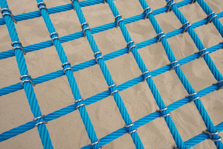 Child safety rope climbing net. Blue playground combination ropes entwined together with metal...