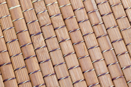 Closeup of intertwined bamboo sticks. Wood background texture