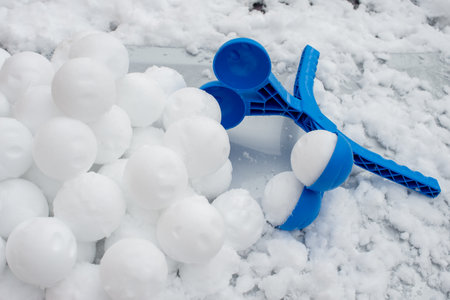 Snowballs formed with manual ball bead machine. Winter fun. Snow fighting toolの写真素材