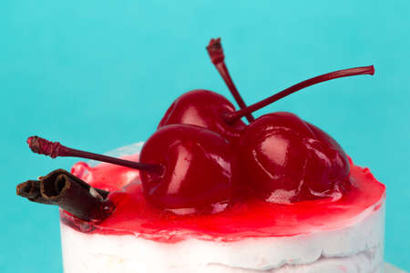 colorful cupcake with a cherry on top on a blue background, macro
の写真素材