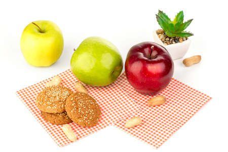 Apples, peanuts, oatmeal cookies and aloe floweron a white tableの写真素材