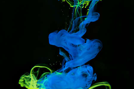 Color paint drops in water. Ink swirling underwater. Cloud of silky ink collision on black background. Colorful abstract smoke explosion animation. Close up camera view.の写真素材