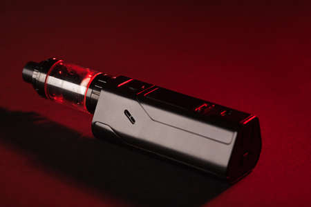 Electronic cigarette over a dark background. E-cigarette for vaping. Popular devicesの写真素材