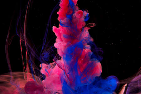 Color paint drops in water. Ink swirling underwater. Cloud of silky ink collision on black background. Colorful abstract smoke explosion animation. Close up camera view.の写真素材
