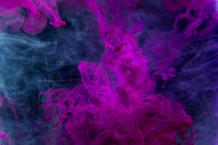 Color paint drops in water. Ink swirling underwater. Cloud of silky ink collision on black background. Colorful abstract smoke explosion animation. Close up camera view.の写真素材