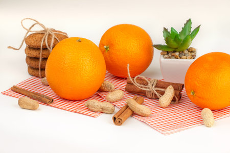 Ripe oranges, peanuts, oatmeal cookies and aloe on a green background