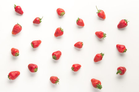 pattern of ripe juicy red strawberries on white table