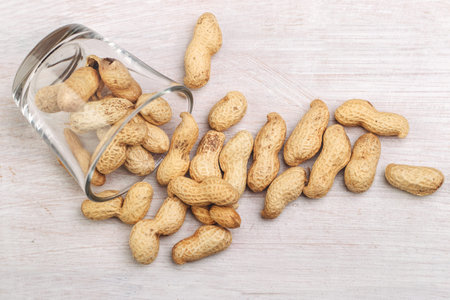 Peanuts on a wooden table. Top view. Peanuts in shell scattered on a wooden table