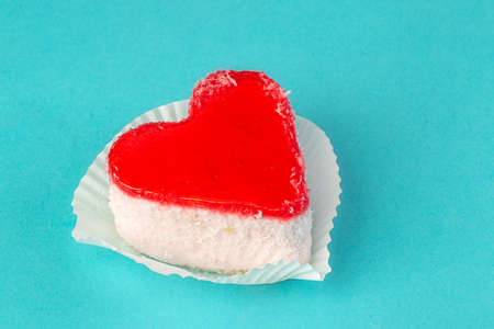 Bright cake in the form of heart with candles on a blue backgroundの写真素材