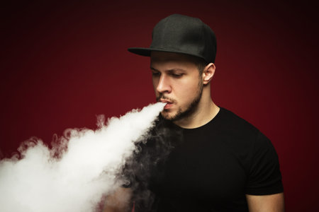 Vaping man. A cloud of vapor. red background.