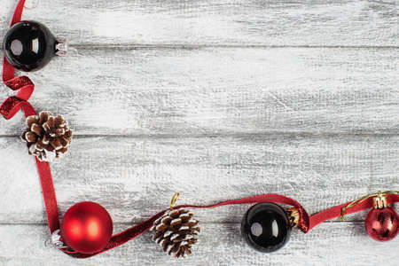 fir cones and red and silvery New Year balls on a wooden backgroundの写真素材