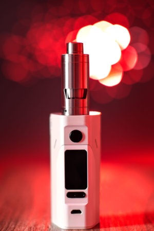 Electronic cigarette over a red background. E-cigarette for vaping. Popular devices