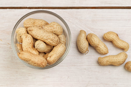 Peanuts on a wooden table. Top view. Peanuts in shell scattered on a wooden table