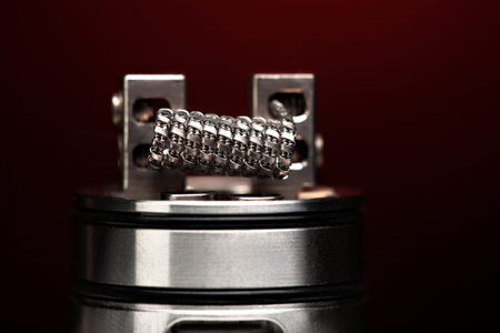 staple staggered fused clapton coil in rebuildable dripping atomizer over dark background