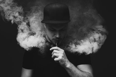 Vaping man. A cloud of vapor. dark background. black and white photography