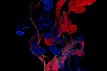 Color paint drops in water. Ink swirling underwater. Cloud of silky ink collision on black background. Colorful abstract smoke explosion animation. Close up camera view.の写真素材