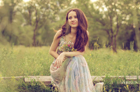 Pretty girl sitting in the meadowの写真素材