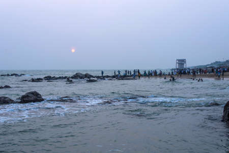 Unidentified pilgrims watch sunrise at Triveni Sangam as the sun rises near Vivekananda Rock Memorial and Thiruvalluvar Statueの写真素材