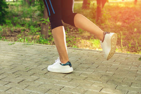 View of the female feet in white sneakers which runs in the Park. Concept of a healthy lifestyleの写真素材