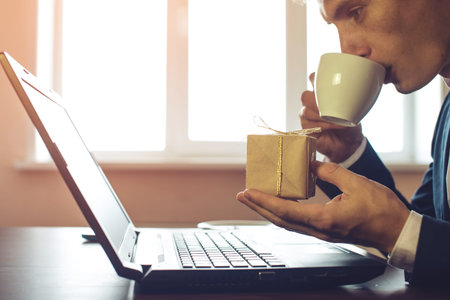 man businessman buying a gift online via credit card, close up view of his hands. the concept of...