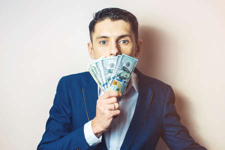 man businessman in a suit with a closed one hundred dollar bills mouth, silent for money. the concept of corruption and briberyの写真素材