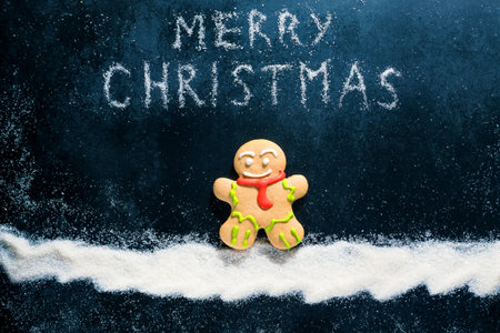 Baking Gingerbread Men for Christmas on dark table, winter snow night