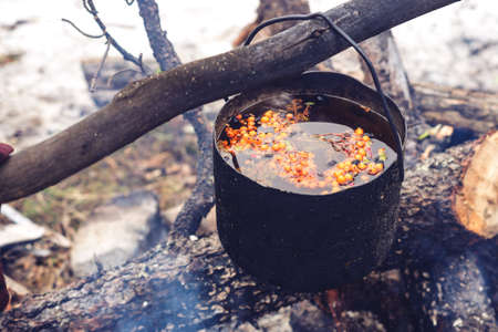 preparation of herbal tea with Rowan over open fire at campsiteの写真素材