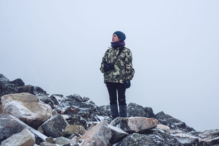the girl in the stones with a camera, looking at nature, travel concept