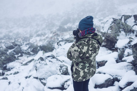 the girl in the stones with a camera, looking at nature, travel concept
