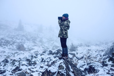 the girl in the stones with a camera, looking at nature, travel concept