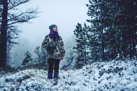 the girl in the woods with a camera looking to nature, concept of travelの写真素材
