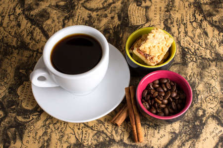 cup of hot espresso coffee, and cookie on a map