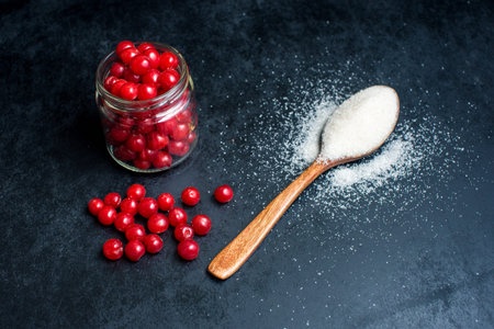 jar of cherries and a spoon with sugar to make jams